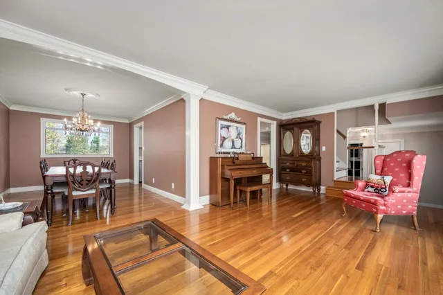 a living room with furniture a dining table and chairs with wooden floor