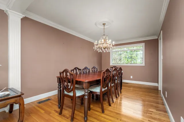a view of a dining room with furniture a chandelier and wooden floor