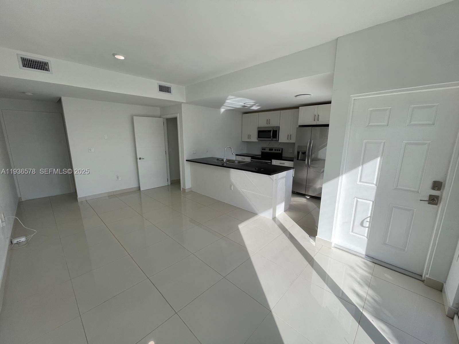 25869 Southwest 139th Court Homestead, FL 33032 - Photo 2 of 22 a large white kitchen with stainless steel appliances a refrigerator a stove a sink and white cabinets