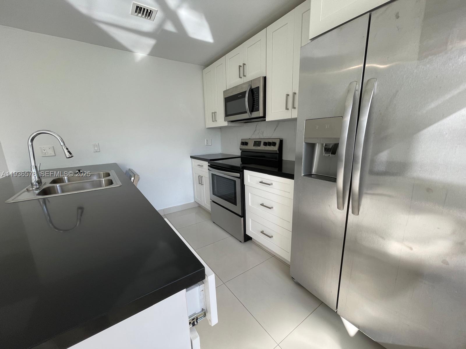 25869 Southwest 139th Court Homestead, FL 33032 - Photo 6 of 22 a kitchen with stainless steel appliances a refrigerator sink and microwave
