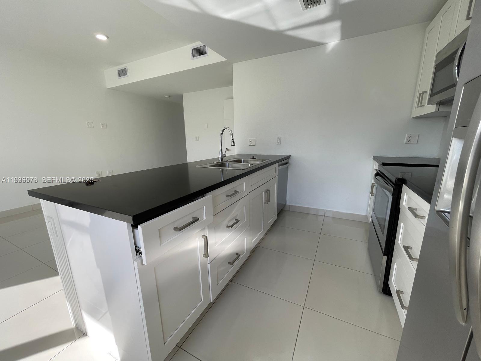 25869 Southwest 139th Court Homestead, FL 33032 - Photo 7 of 22 a kitchen with a sink and a refrigerator