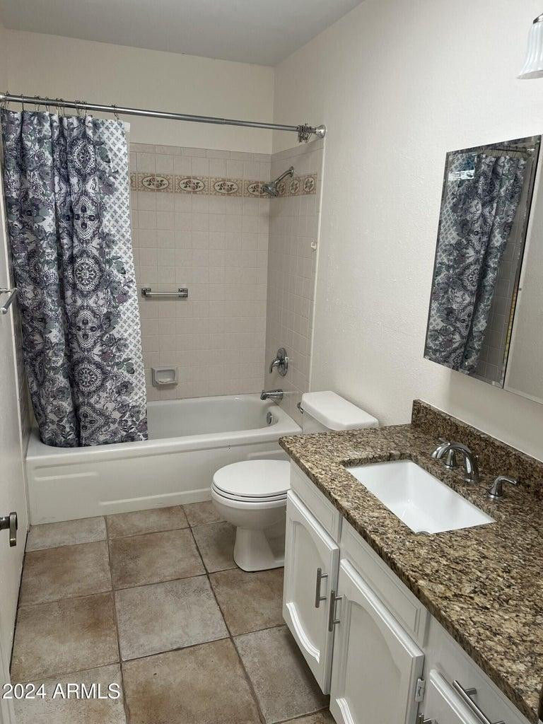 16623 North 29th Drive Phoenix, AZ 85053 - Photo 7 of 13 a bathroom with a granite countertop sink a toilet and shower