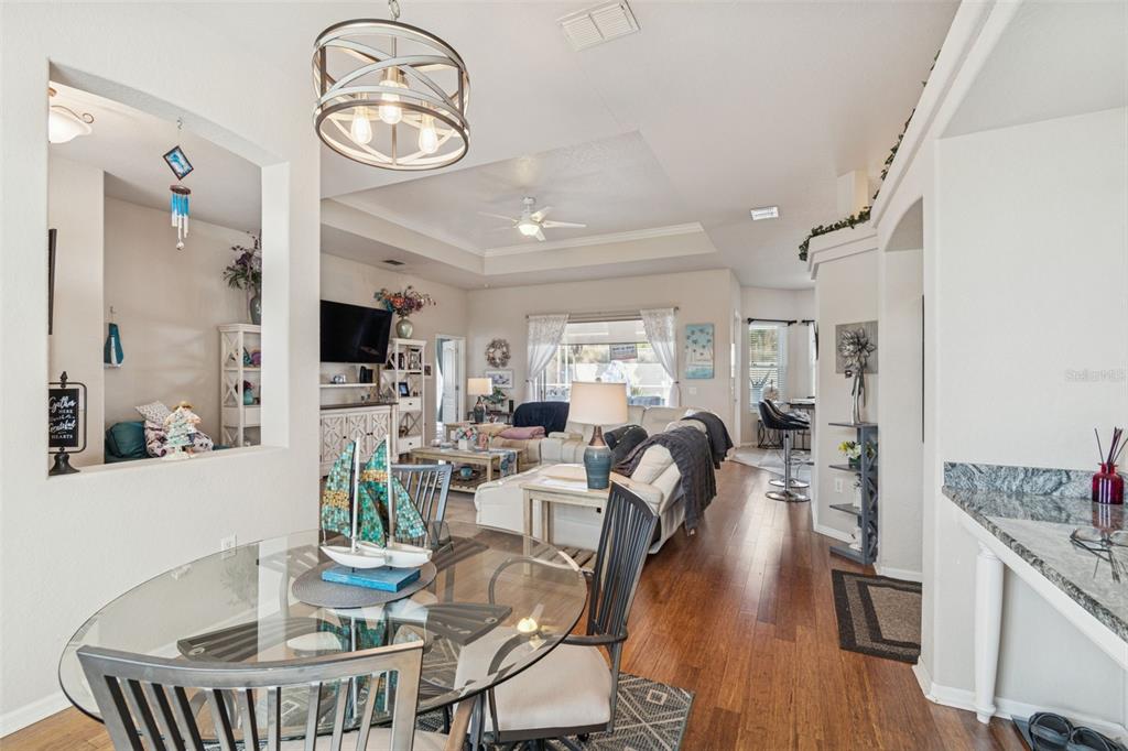 5287 Slater Road Spring Hill, FL 34608 - Photo 17 of 86 a view of a dining room with furniture a chandelier and wooden floor