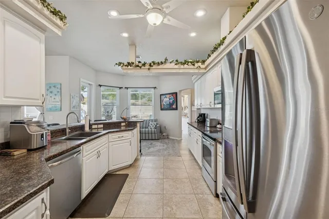 a bathroom with a granite countertop sink a large mirror a bathtub and next to a window