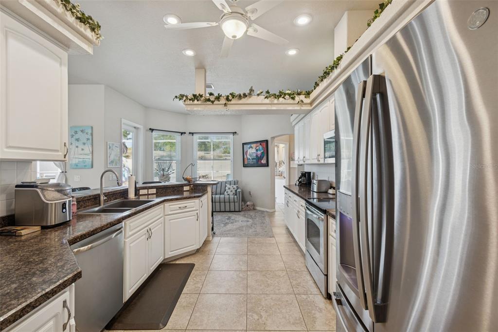 5287 Slater Road Spring Hill, FL 34608 - Photo 22 of 86 a large kitchen with a large counter top space a sink stainless steel appliances and cabinets
