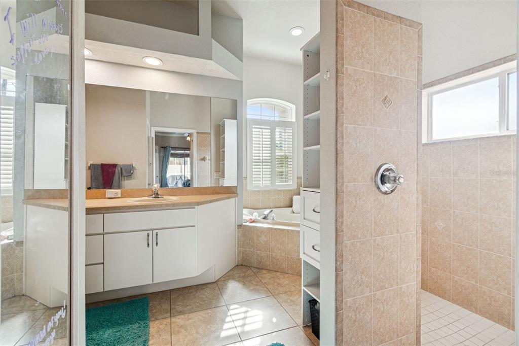 5287 Slater Road Spring Hill, FL 34608 - Photo 31 of 86 a spacious bathroom with a double vanity sink a mirror and a shower