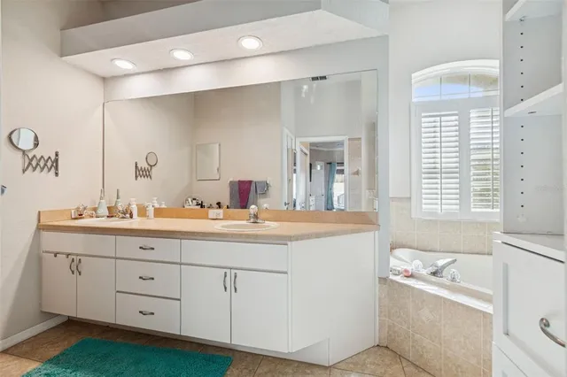 a kitchen with a chandelier a sink stainless steel appliances and cabinets