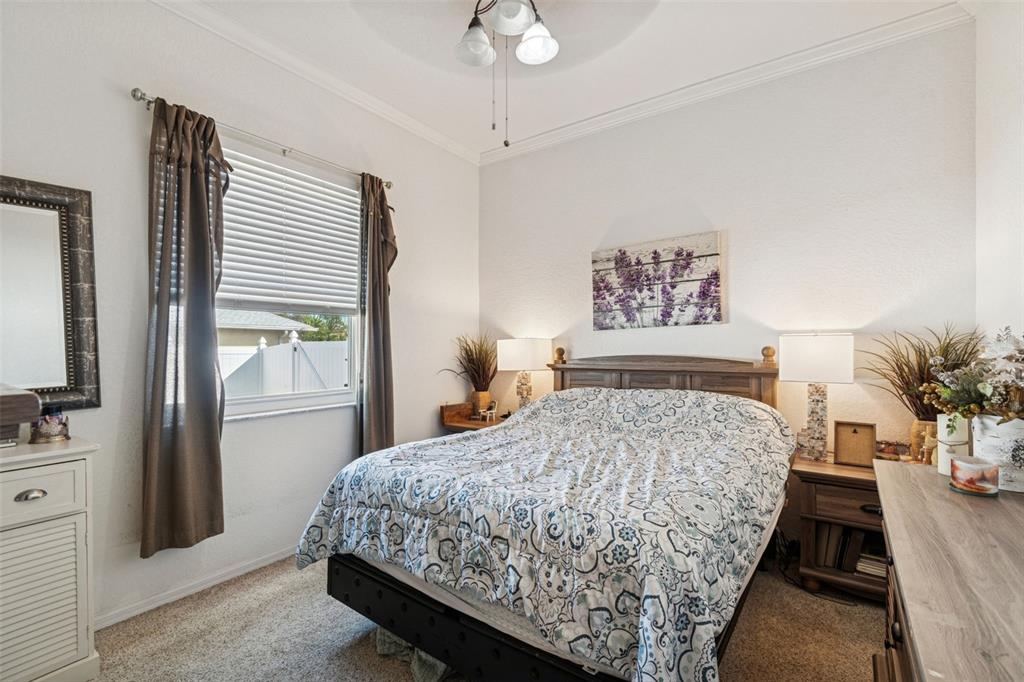 5287 Slater Road Spring Hill, FL 34608 - Photo 43 of 86 a bedroom with a large bed and a chandelier