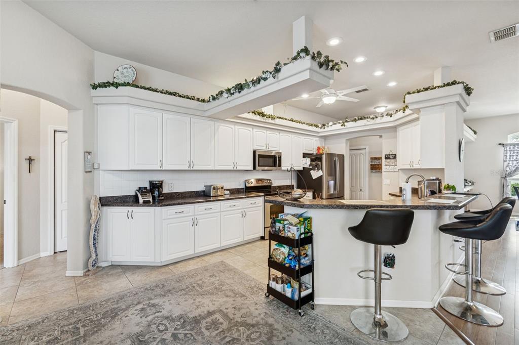 5287 Slater Road Spring Hill, FL 34608 - Photo 49 of 86 a kitchen with a chandelier a sink stainless steel appliances and cabinets