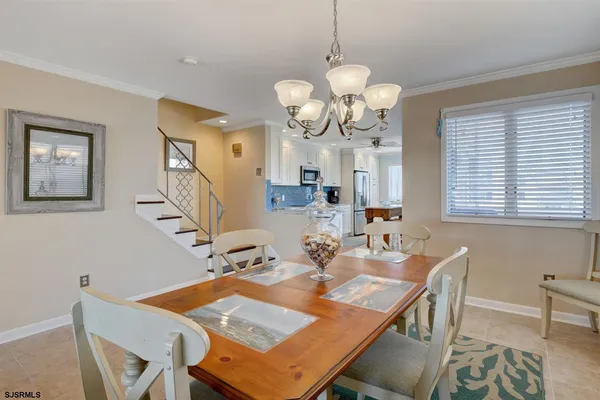 a view of a dining room with furniture a chandelier and a window