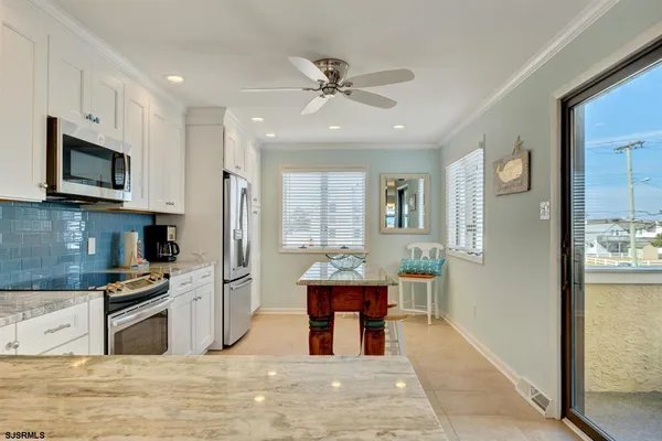 a open kitchen with stainless steel appliances granite countertop a refrigerator stove top oven and sink