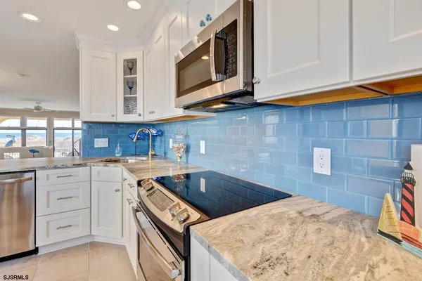 a kitchen with granite countertop a sink a stove and cabinets