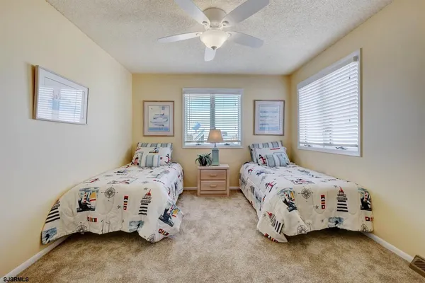 a bedroom with two beds and a chandelier