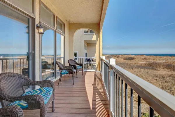 a balcony with wooden floor and outdoor seating