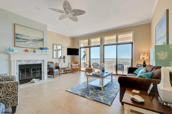 a living room with furniture a fireplace and a floor to ceiling window