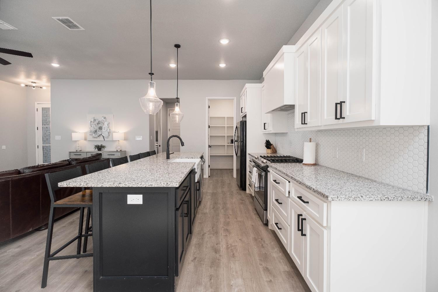 5921 Harvard Street Lubbock, TX 79416 - Photo 13 of 34 a kitchen with stainless steel appliances granite countertop a sink a stove and a refrigerator