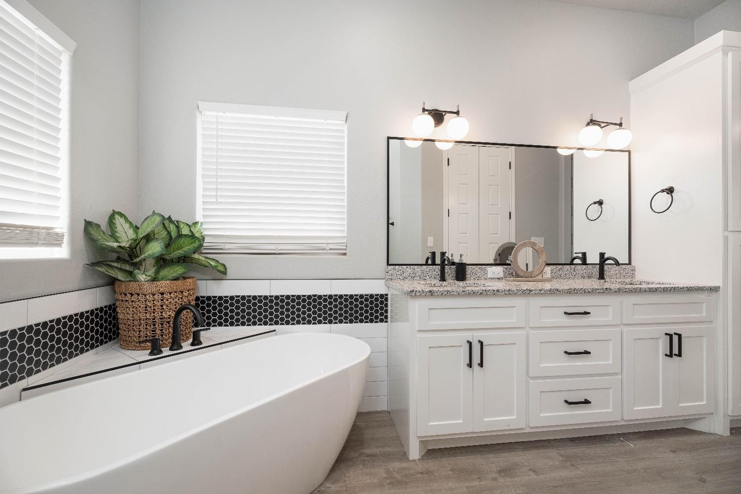 5921 Harvard Street Lubbock, TX 79416 - Photo 23 of 34 a bathroom with a granite countertop sink a bathtub a mirror a vanity and a bathtub