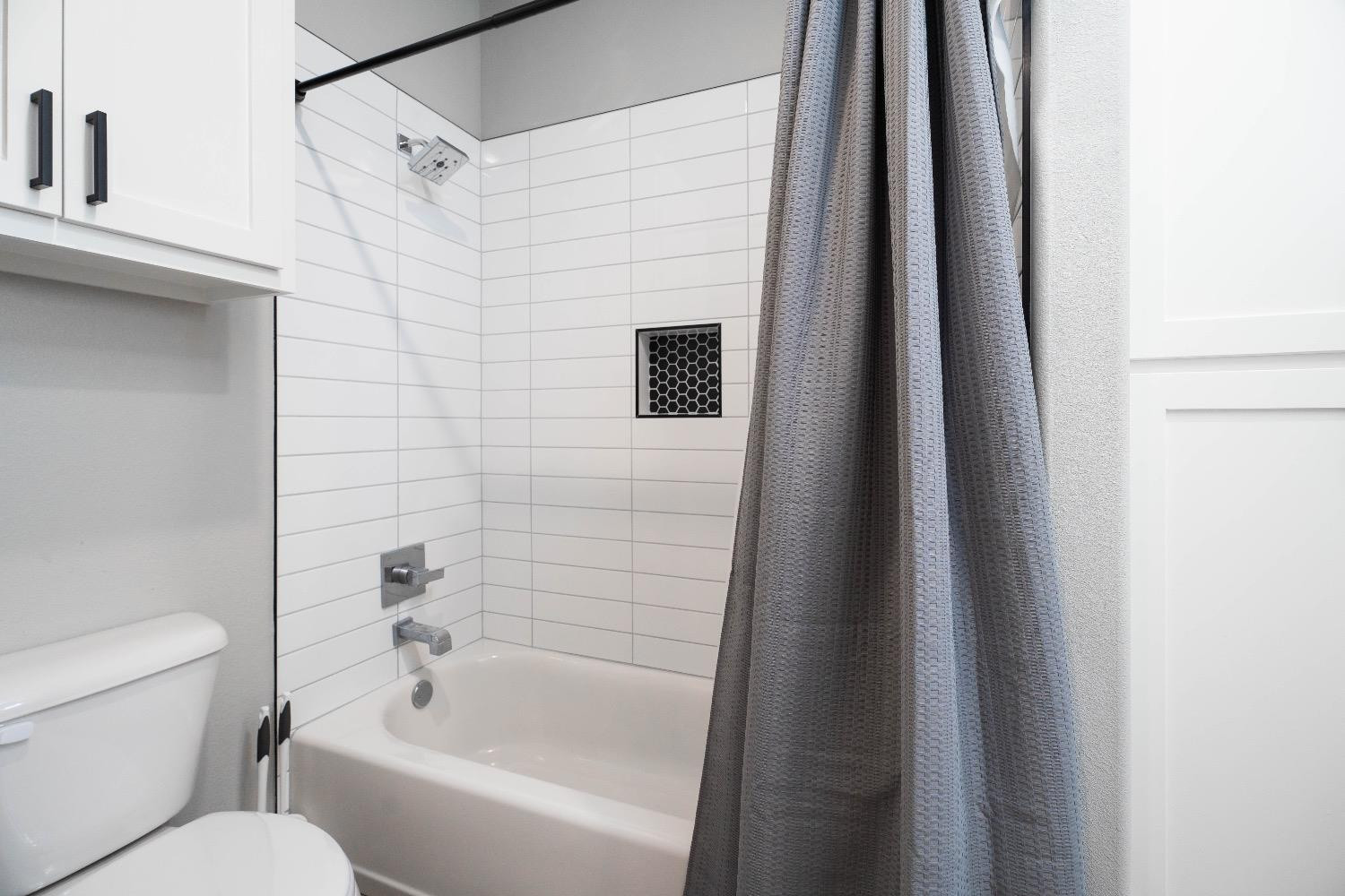 5921 Harvard Street Lubbock, TX 79416 - Photo 28 of 34 a bathroom with a toilet and a bathtub