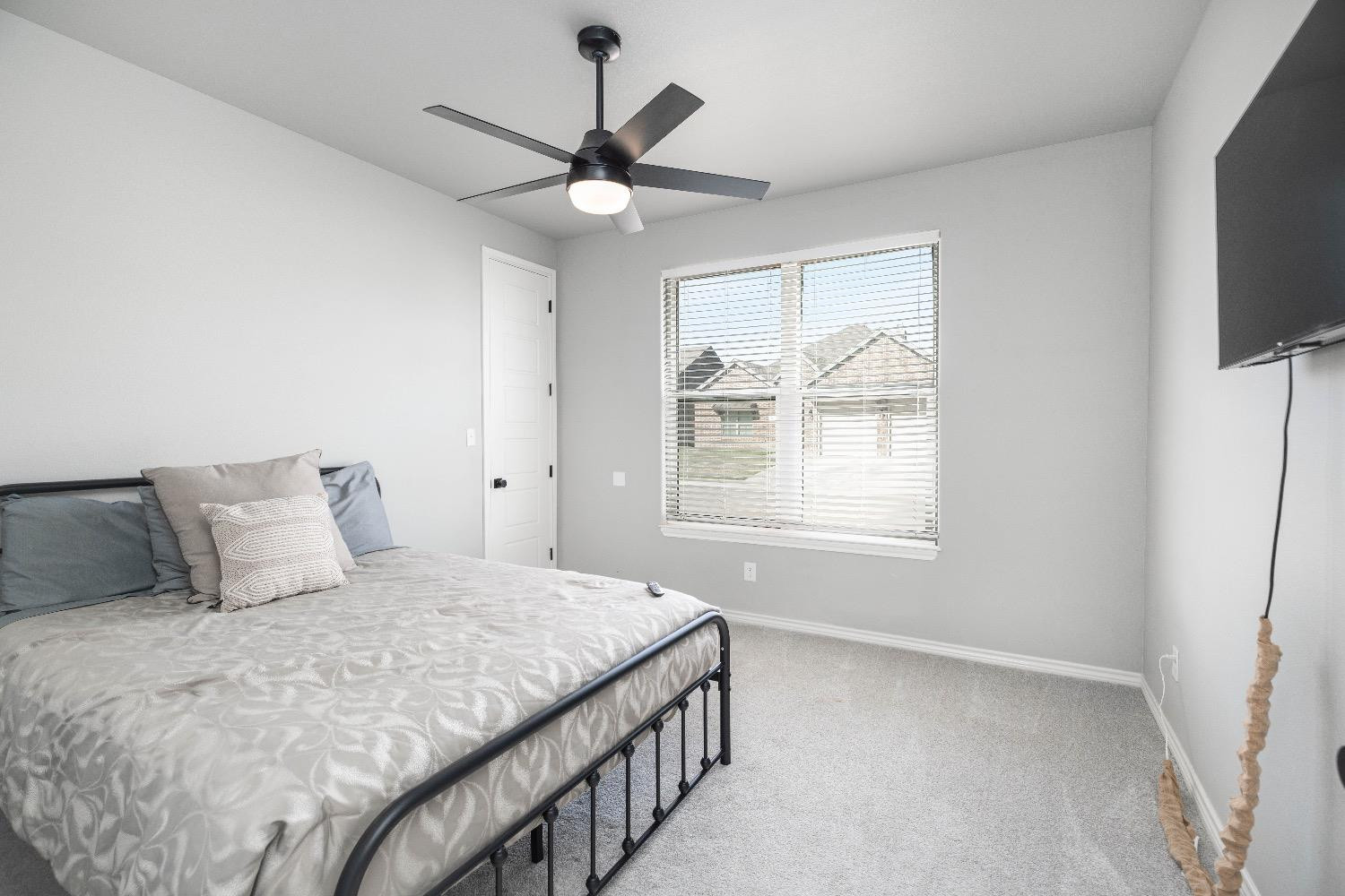 5921 Harvard Street Lubbock, TX 79416 - Photo 30 of 34 a bedroom with a large bed and a tv