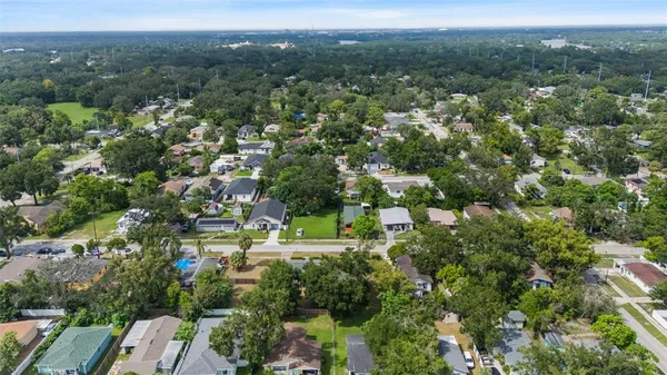 an aerial view of residential houses with outdoor space and trees