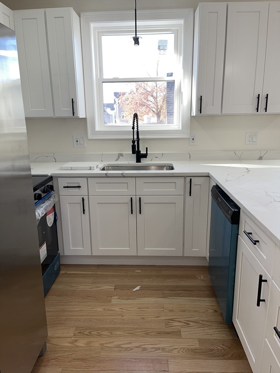 136 Houston Street Providence, RI 02905 - Photo 2 of 15 a kitchen with sink cabinets and window