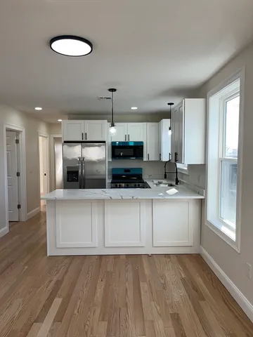 a kitchen with stainless steel appliances granite countertop a stove a sink and a refrigerator