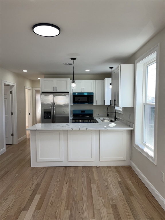 136 Houston Street Providence, RI 02905 - Photo 3 of 15 a kitchen with stainless steel appliances granite countertop a stove a sink and a refrigerator