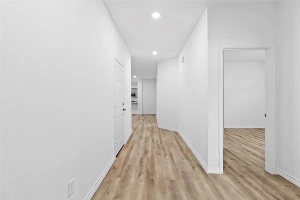 a view of a hallway with wooden floor and staircase
