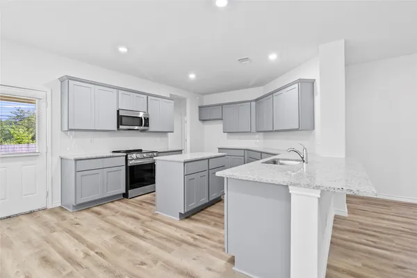 a kitchen with a stove a sink and a microwave