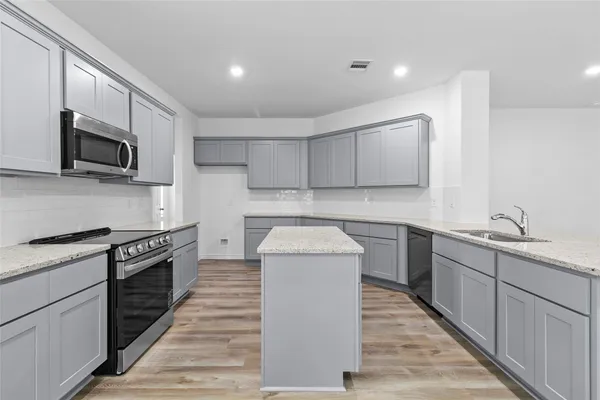 a kitchen with a sink stove and microwave