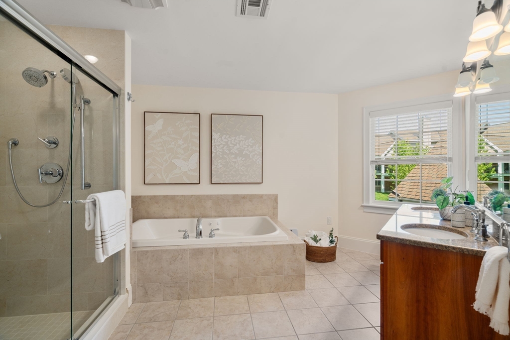 287 Langley Road, Unit 43 Newton, MA 02459 - Photo 27 of 36 a spacious bathroom with a tub sink and mirror