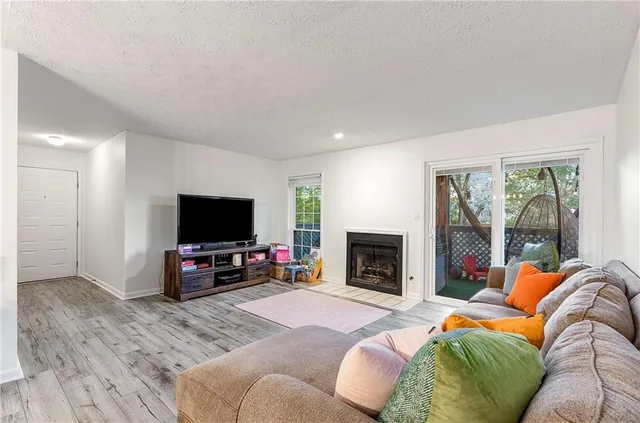 a living room with furniture a flat screen tv and a fireplace
