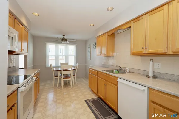 a kitchen with a stove a sink a dining table and chairs