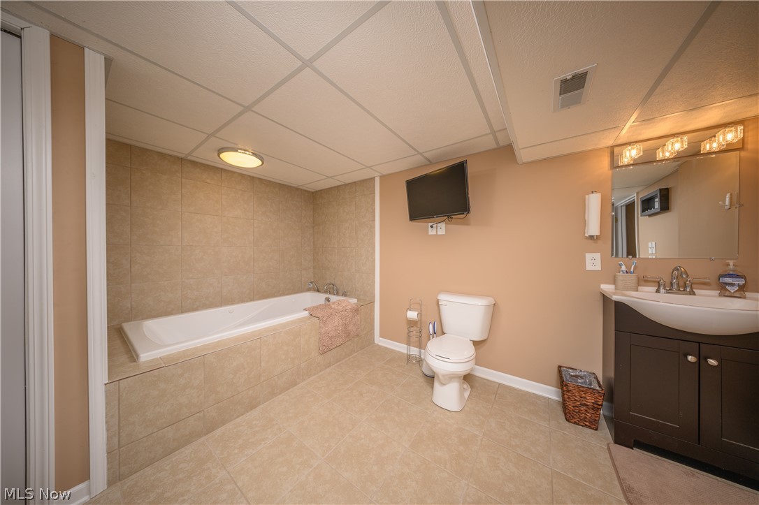 4431 7th Street Northwest Canton, OH 44708 - Photo 17 of 23 Full bathroom with vanity, a drop ceiling, and light tile patterned floors