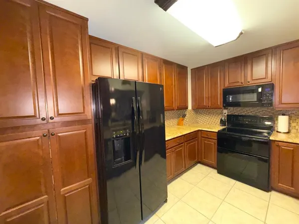 a kitchen with a refrigerator a stove and a sink with wooden floor