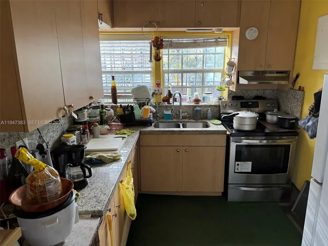 a kitchen with a sink stove and cabinets
