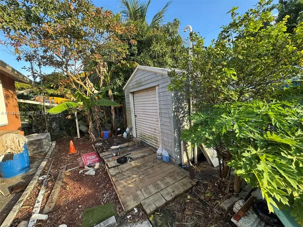 a backyard of a house with table and chairs and potted plants