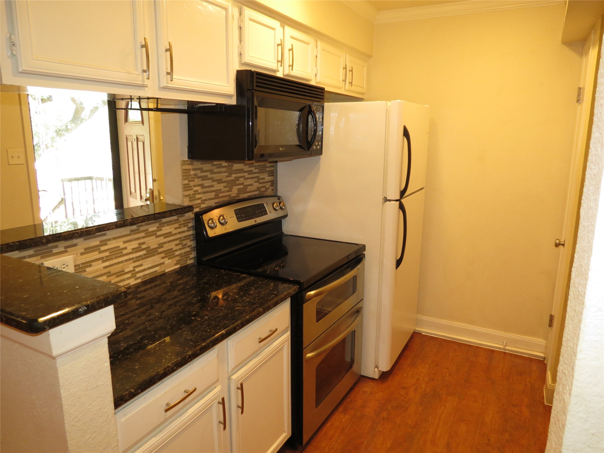 4159 Steck Avenue, Unit 269 Austin, TX 78759 - Photo 7 of 21 Streamlined kitchen featuring dark granite countertops and white cabinetry.