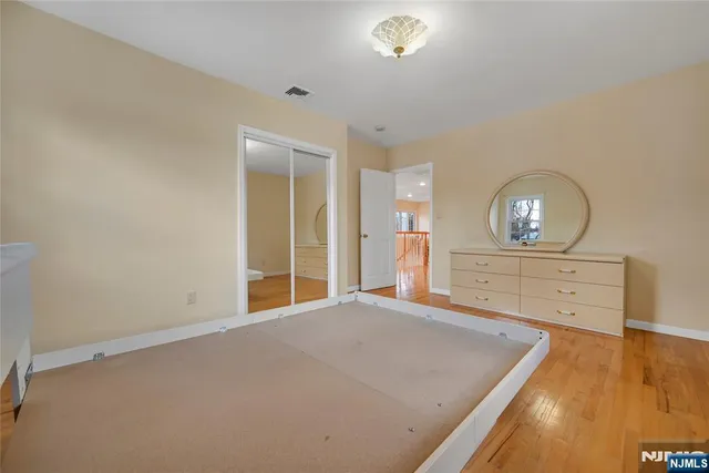 a view of empty room with wooden floor and air conditioner
