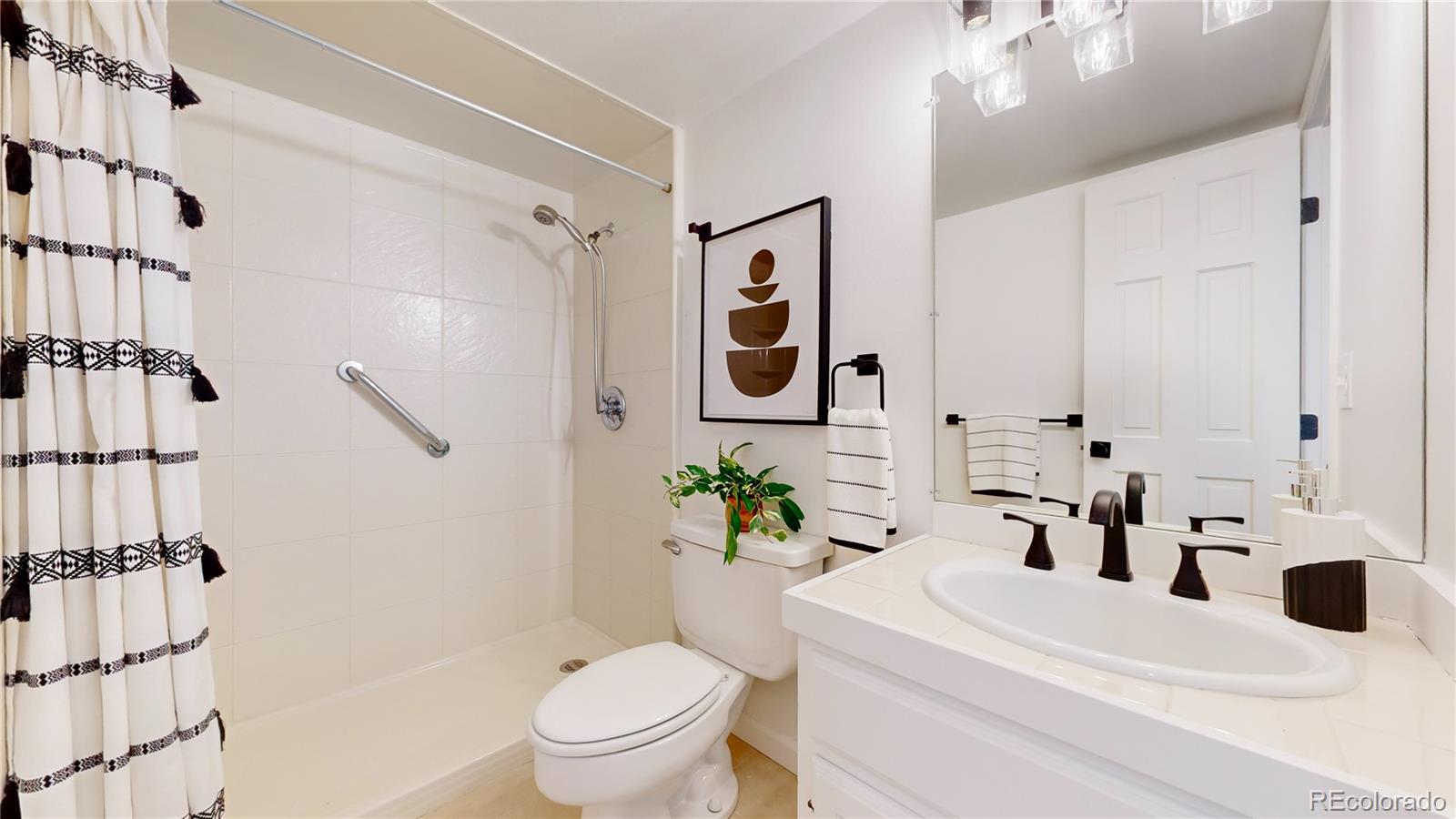 357 Harrison Street Denver, CO 80206 - Photo 19 of 40 a bathroom with a sink a toilet and shower