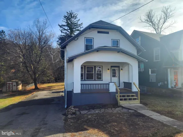 a view of empty room with fireplace and wooden floor