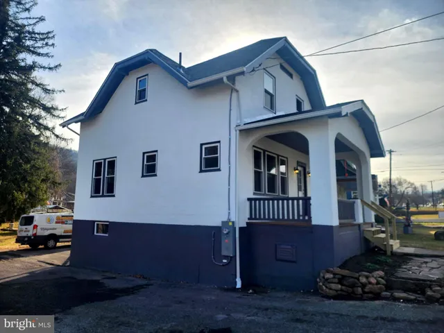 a view of a livingroom with wooden floor and staircase