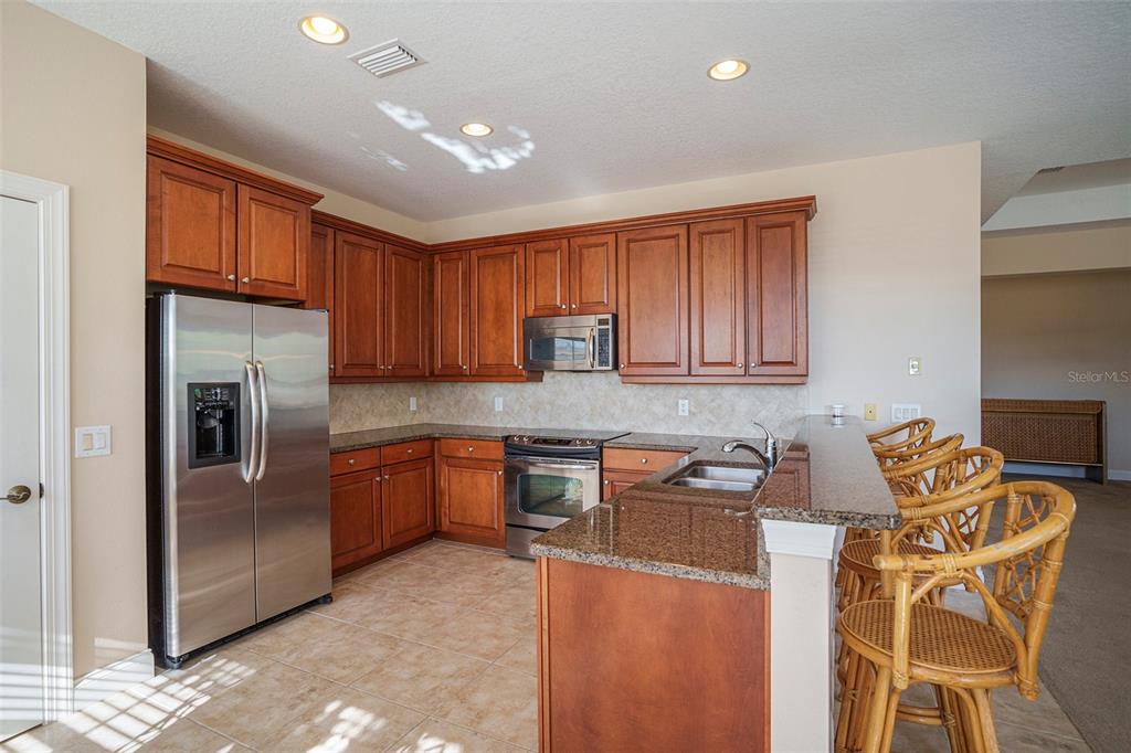 320 Ibisview Lane Apollo Beach, FL 33572 - Photo 15 of 30 a kitchen with stainless steel appliances granite countertop a refrigerator sink and cabinets