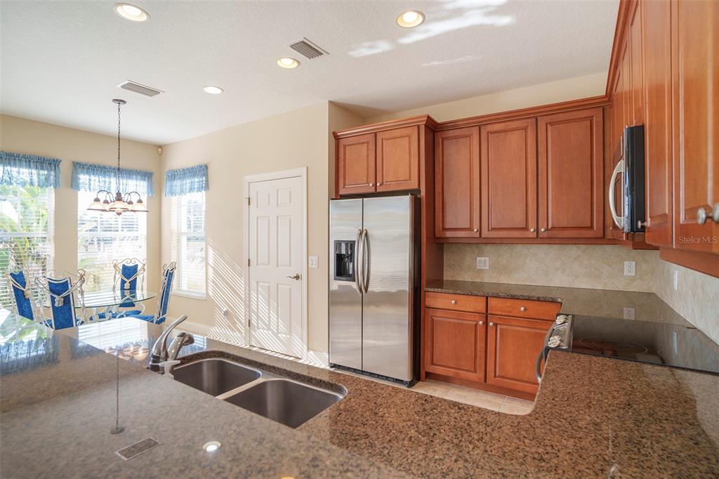 320 Ibisview Lane Apollo Beach, FL 33572 - Photo 17 of 30 a kitchen with stainless steel appliances granite countertop a sink and a refrigerator