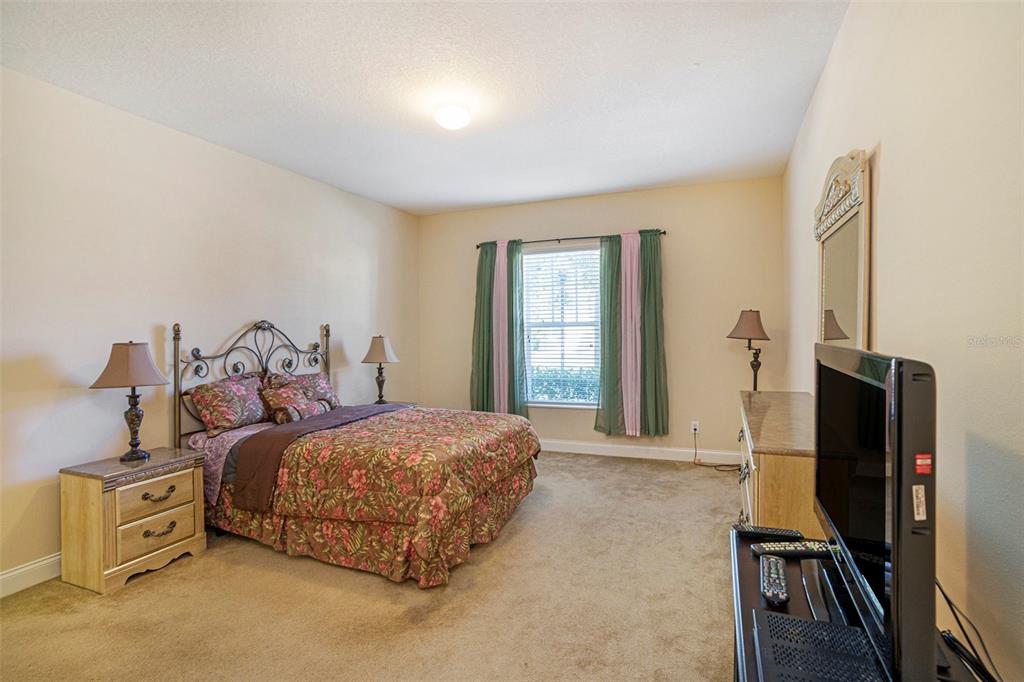 320 Ibisview Lane Apollo Beach, FL 33572 - Photo 25 of 30 a bedroom with a bed and a flat tv screen on a dresser
