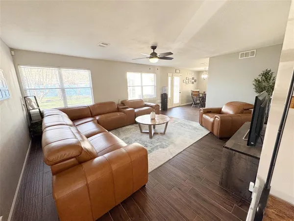 a living room with furniture fireplace and large windows