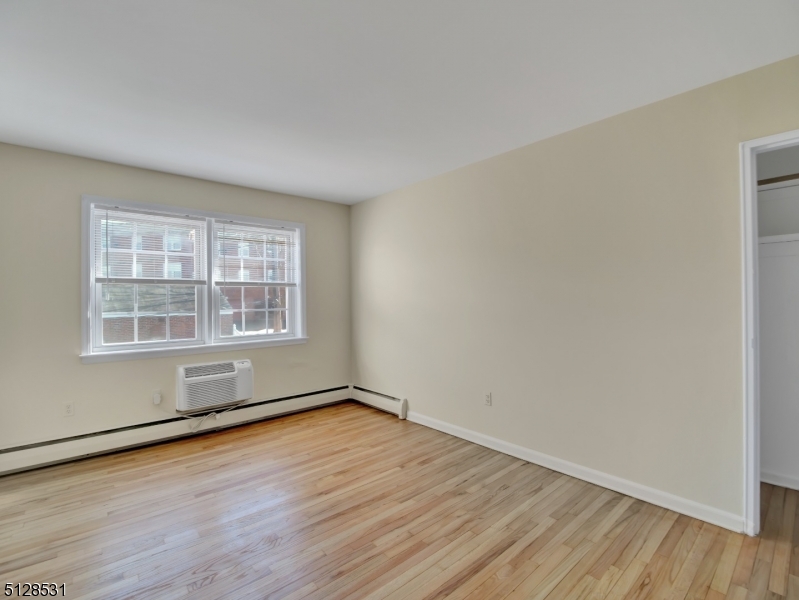 153 Ridge Road, Unit D Cedar Grove, NJ 07009 - Photo 13 of 21 an empty room with wooden floor and windows
