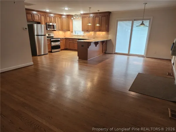 a large kitchen with stainless steel appliances kitchen island granite countertop a stove and a refrigerator