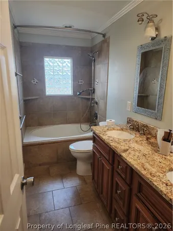 a bathroom with a granite countertop toilet a sink and a mirror