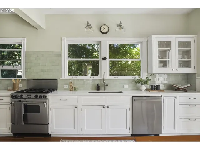 a kitchen with stainless steel appliances granite countertop a stove a sink and a microwave